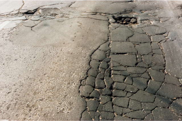 Cracked Road Surface with Potholes